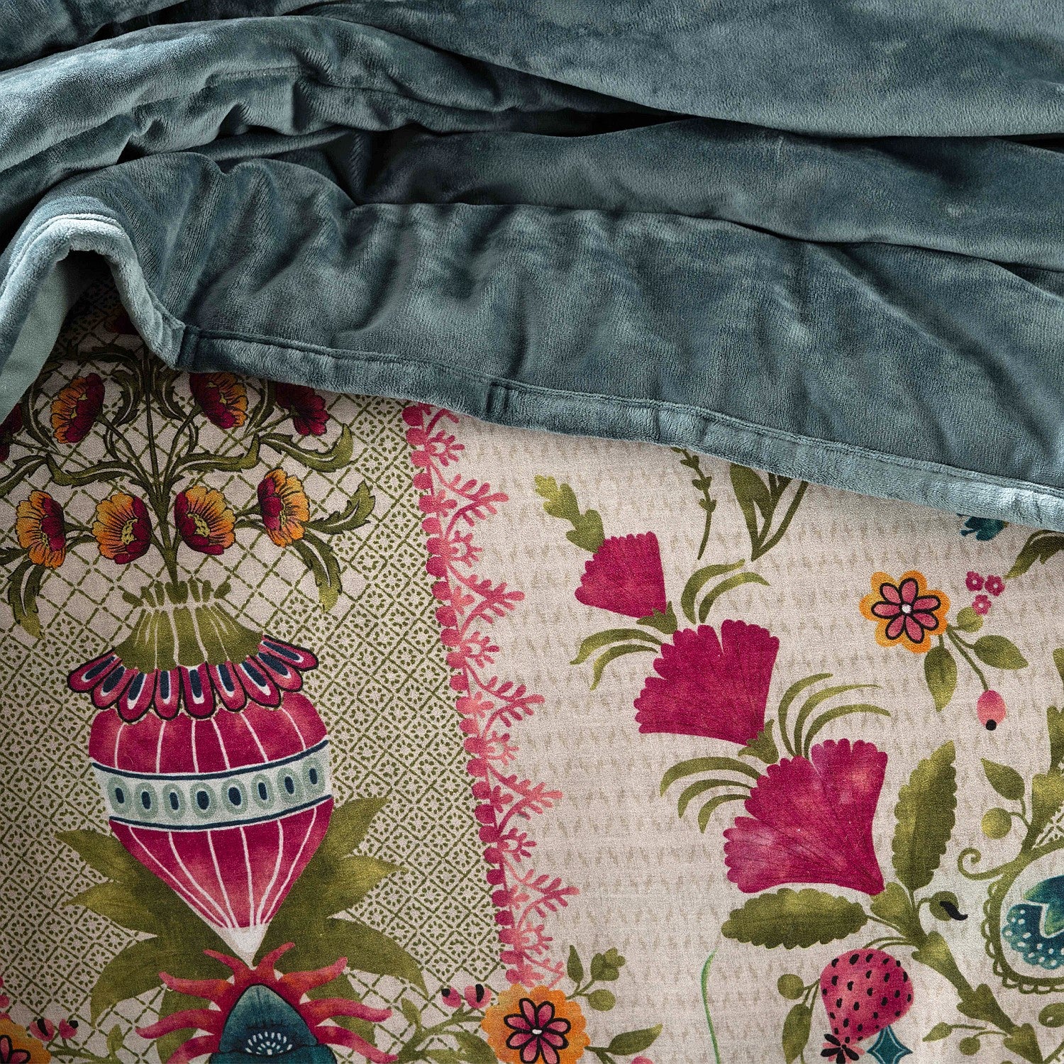 Floral quilt with a blue blanket draped over it