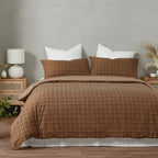 Brown checkered duvet set on a bed with white pillows in a bedroom setting.