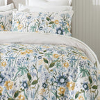 Floral bedding set with blue, yellow, and green flowers on a bed.