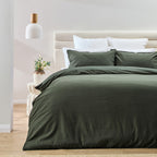 Bed with green bedding in a bedroom setting