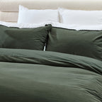 Green bedding set on a bed with white pillows