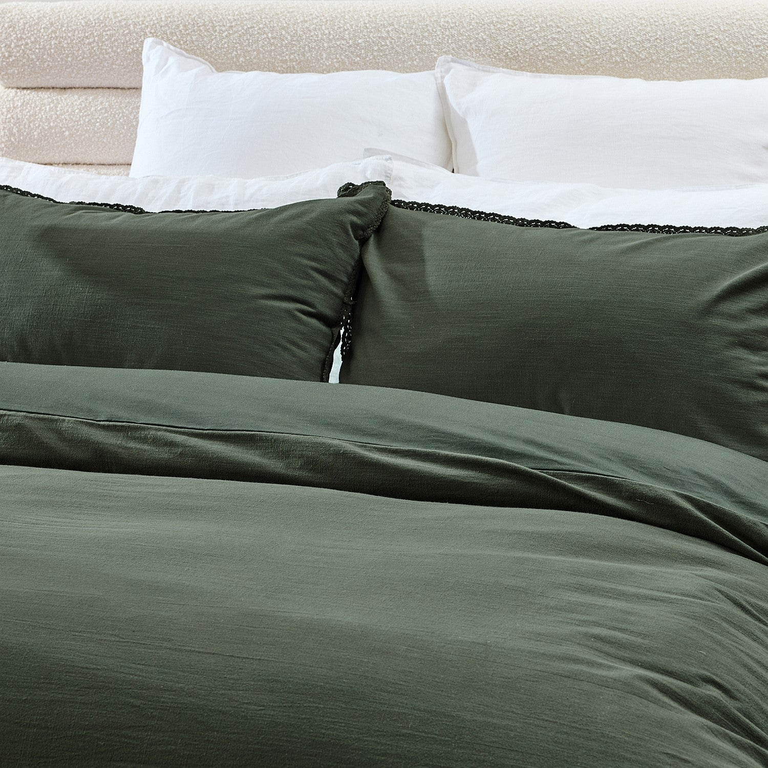 Green bedding set on a bed with white pillows