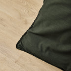 Dark green fabric corner on a wooden surface