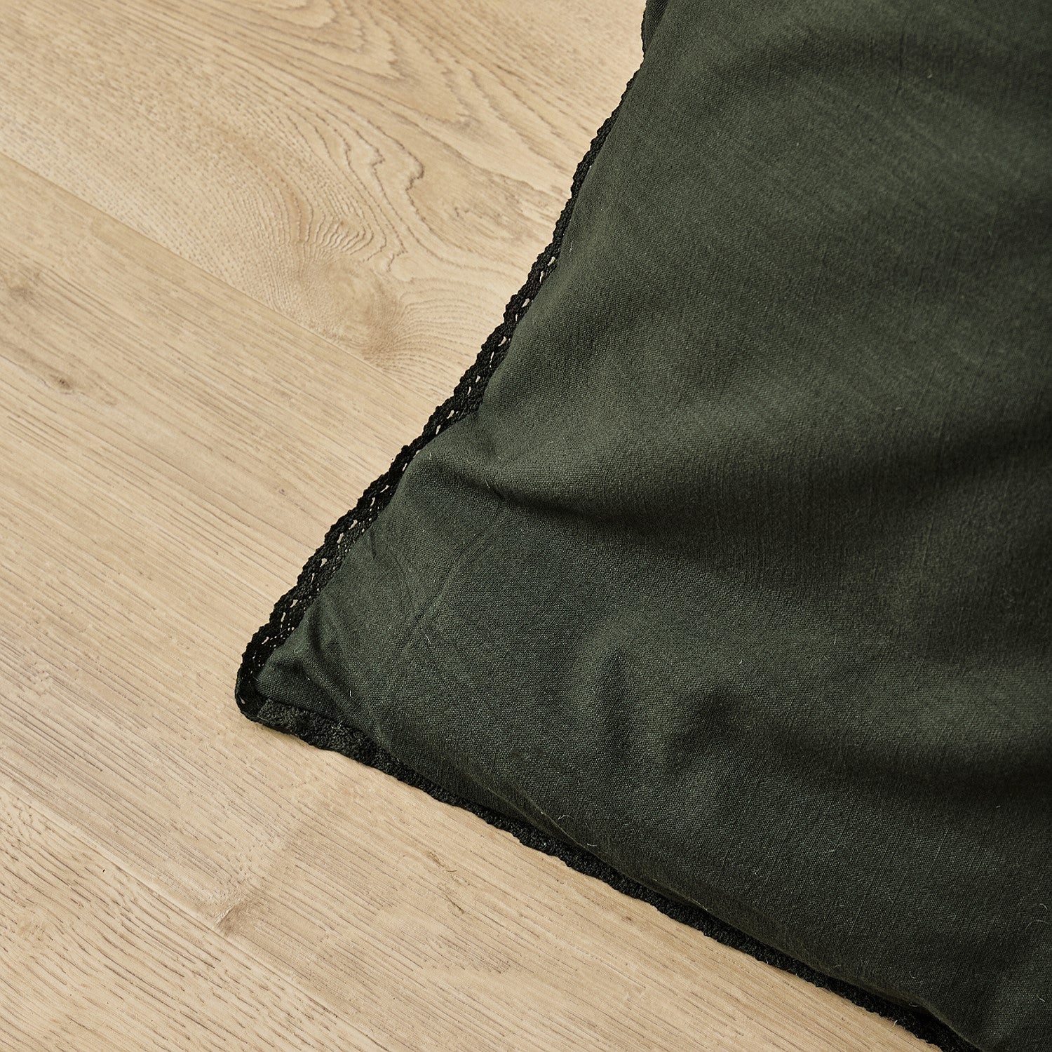 Dark green fabric corner on a wooden surface