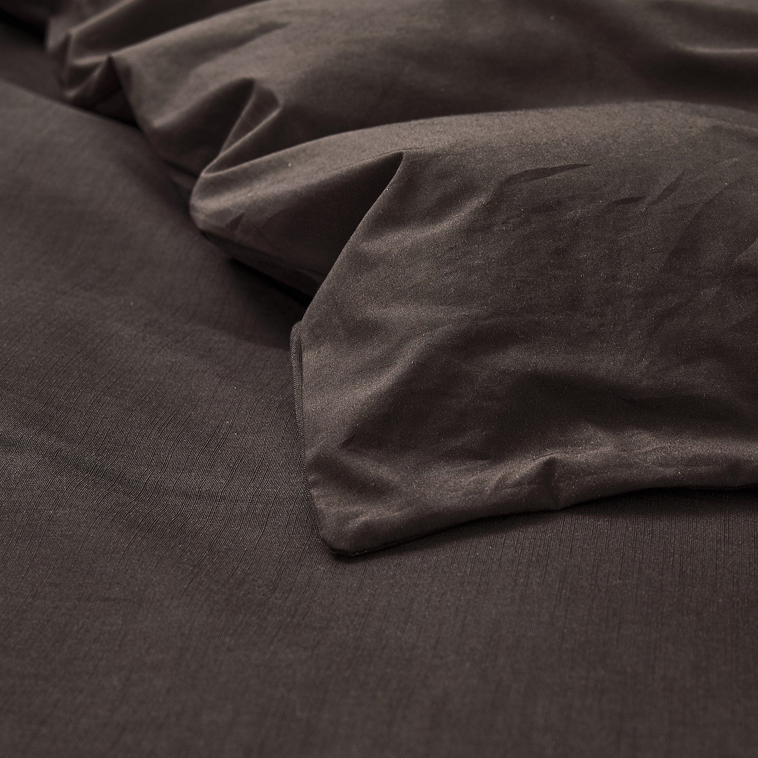 Dark brown fitted sheet on a bed