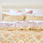 Floral patterned bedding set on a bed with a white headboard.