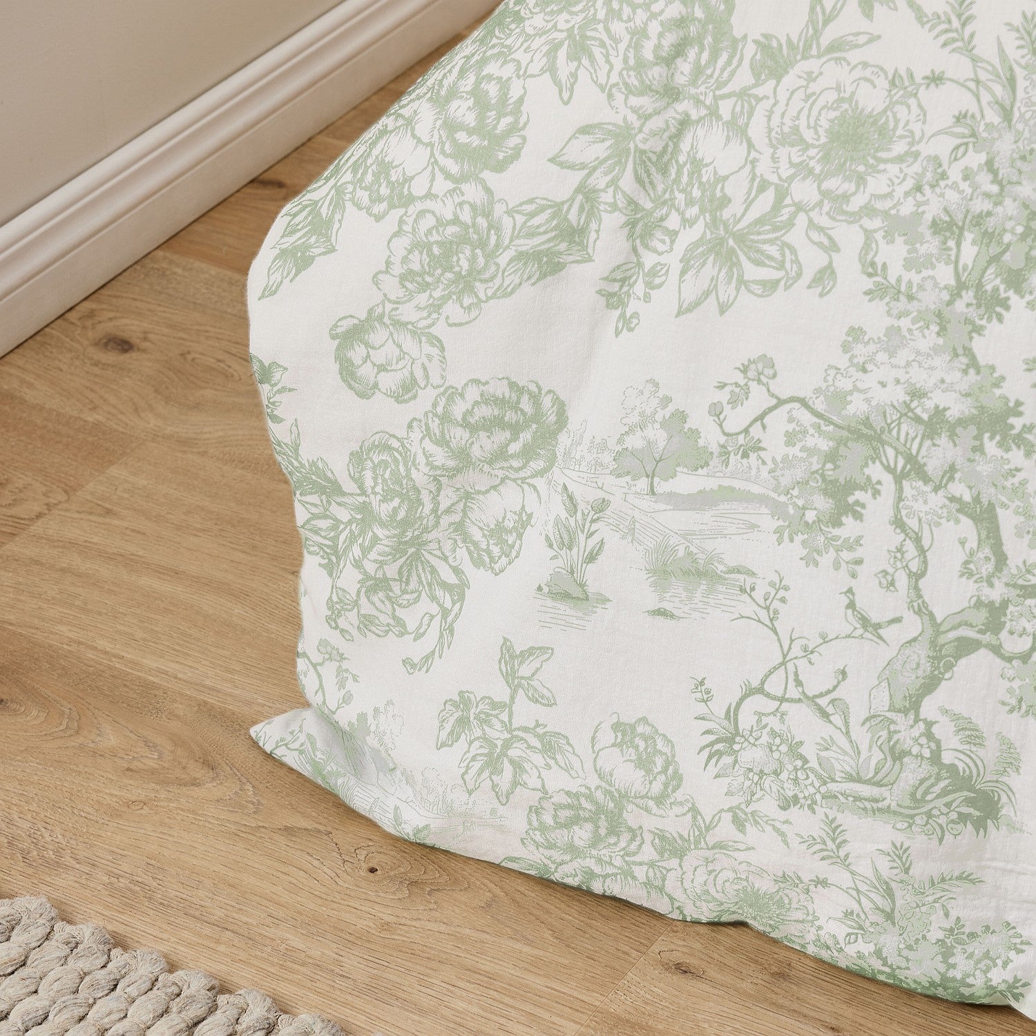 Floral-patterned bedskirt on a wooden floor
