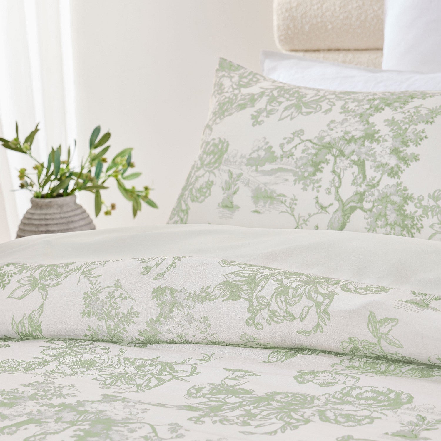 Floral patterned bedding set on a bed with a plant in the background