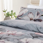 Floral patterned bedding set on a bed with a vase of flowers in the background.