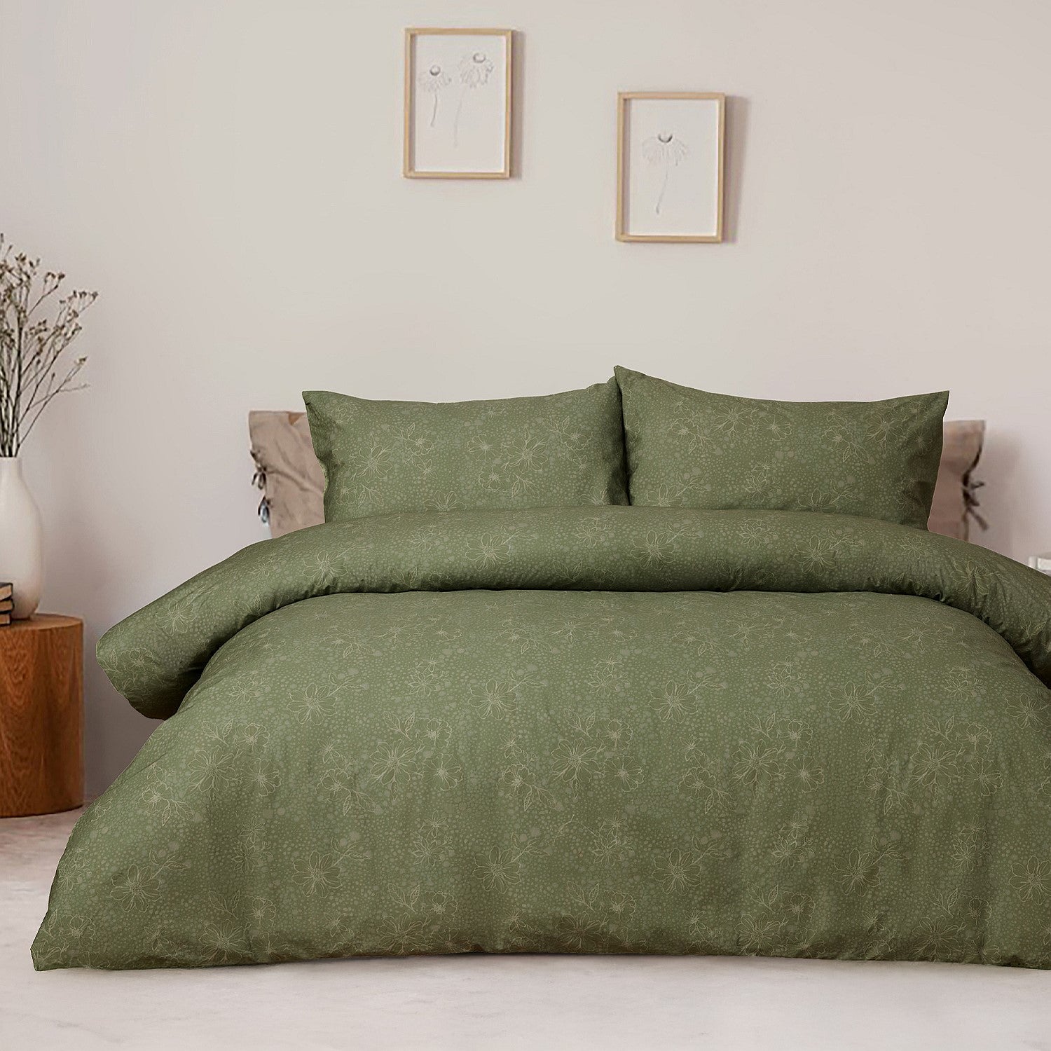 Green patterned bedding set on a bed in a bedroom with framed pictures on the wall.