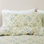 Floral patterned bed sheets and pillows on a bed with a neutral background