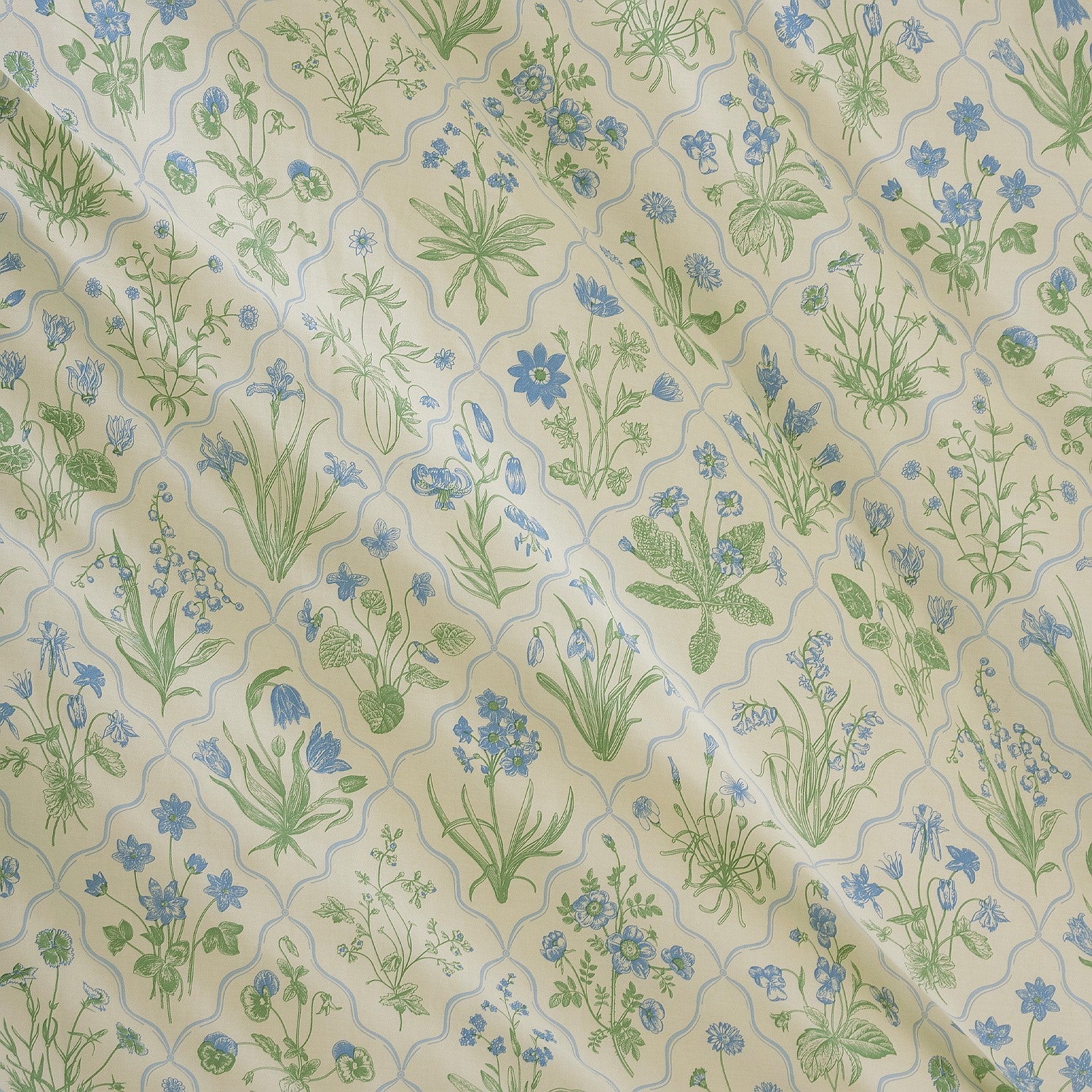 Patterned fabric with green and blue floral design on beige background