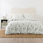 Floral patterned bedding set on a bed with a nightstand in the background