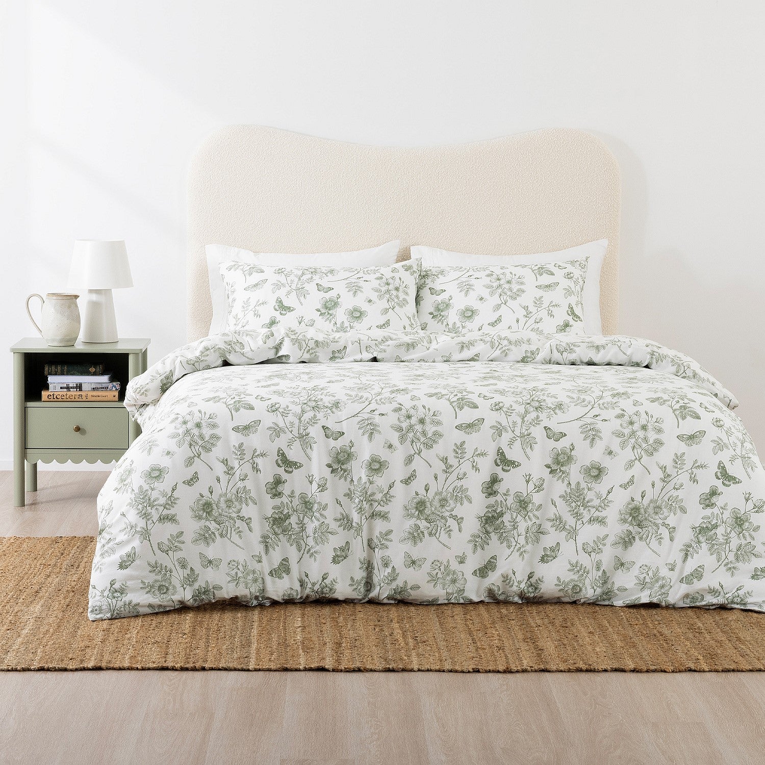 Floral patterned bedding set on a bed with a nightstand in the background