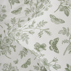 Fabric with green floral and butterfly pattern on a light gray background