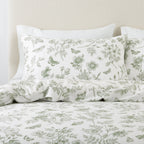 Floral and butterfly patterned bedding set on a bed with a neutral headboard.