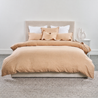 Beige duvet cover set on a bed with white pillows in a minimalistic bedroom.
