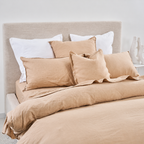 Beige bedding set with pillows on a bed in a bedroom setting