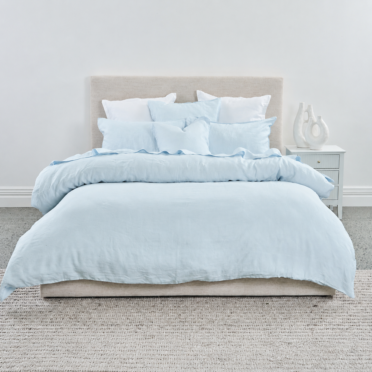 Light blue bedding set on a bed in a bedroom setting