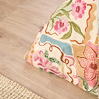 Floral-patterned cushion on a wooden floor