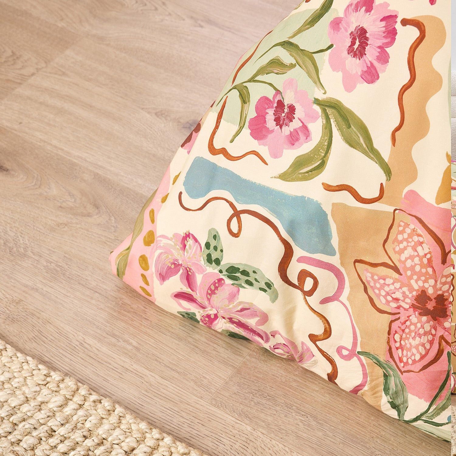 Floral-patterned cushion on a wooden floor