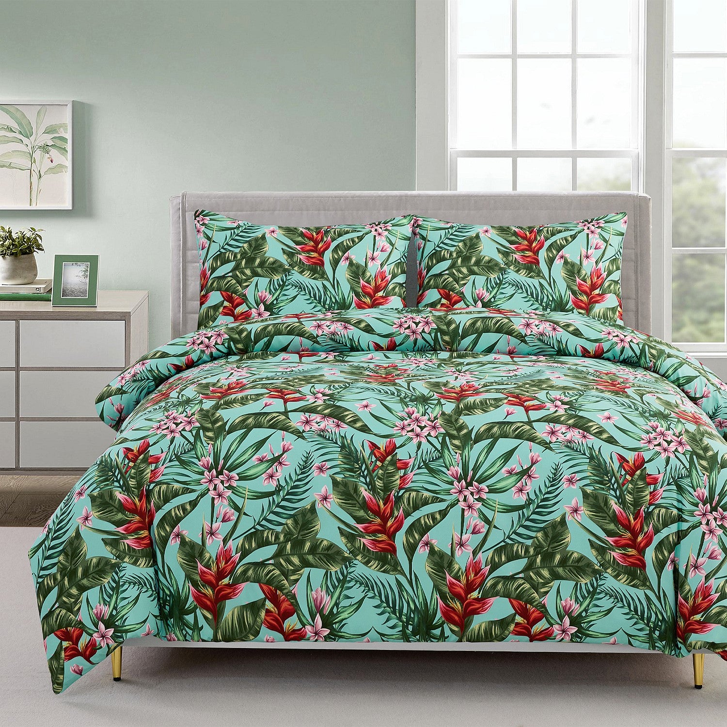 Tropical floral bedding set on a bed with a dresser and window in the background.