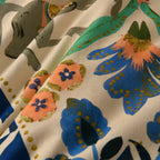 Close-up of fabric with floral pattern featuring blue, orange, and green colors.