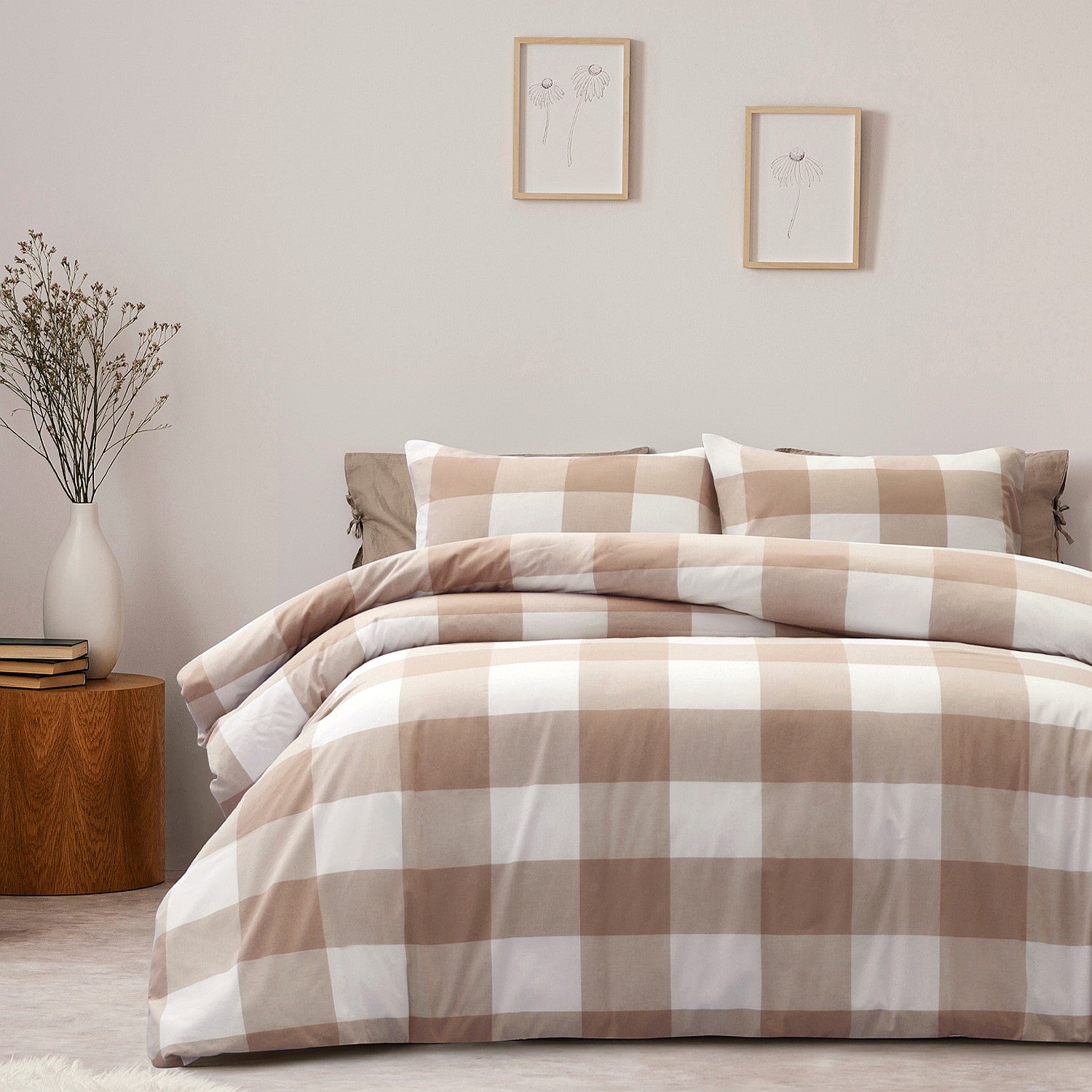 Plaid bedding set on a bed in a bedroom with a side table and decor.