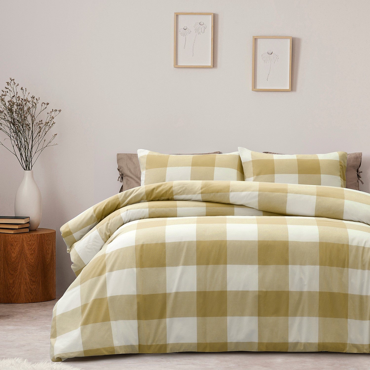 Checkered yellow and white bedding set on a bed in a bedroom with a side table and decor.