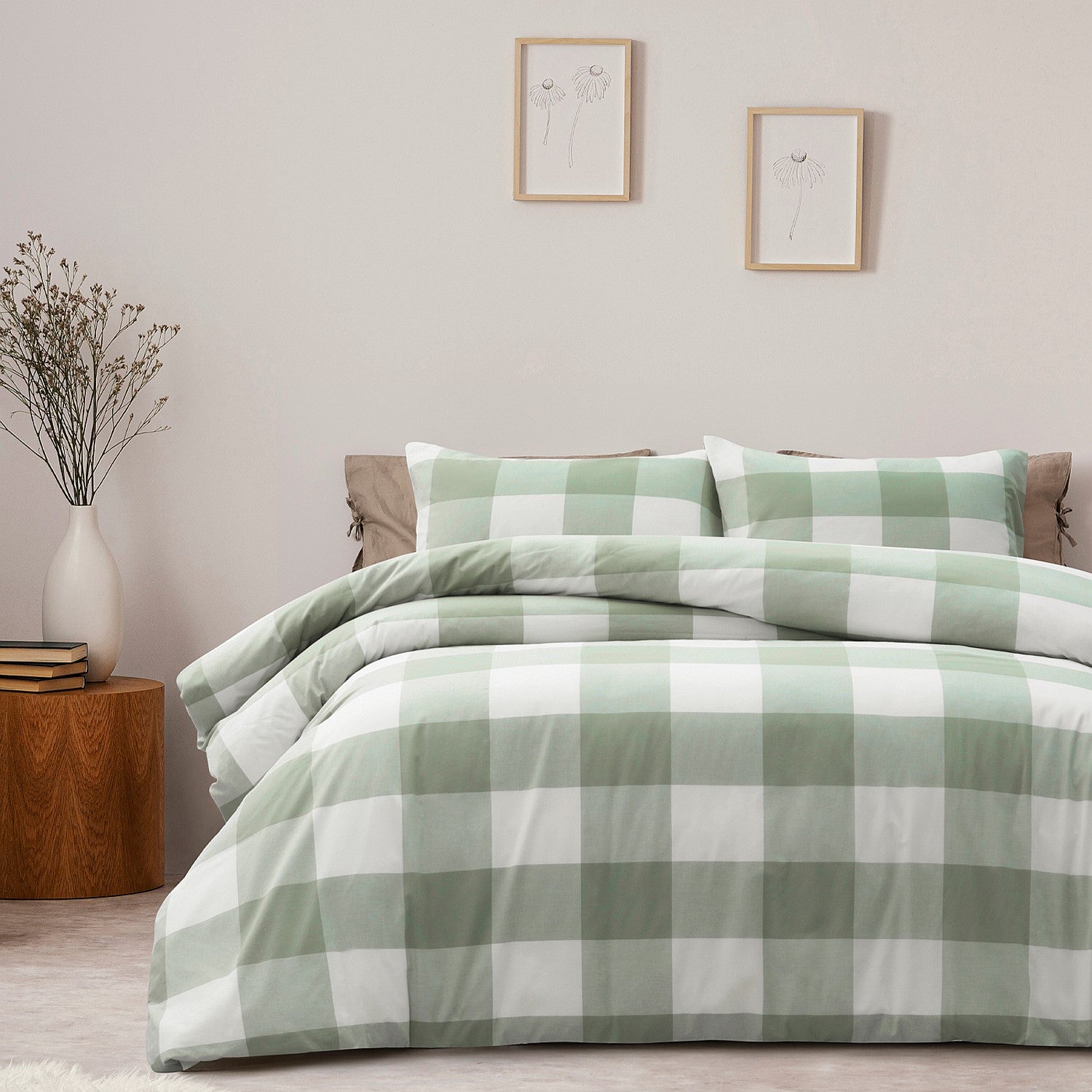 Green and white checkered bedding set on a bed in a bedroom with a side table and decor.