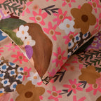 Close-up of floral-patterned fabric with pink, brown, and green colors.