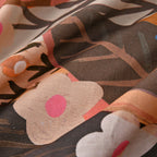 Close-up of fabric with abstract floral pattern in brown, pink, and orange.