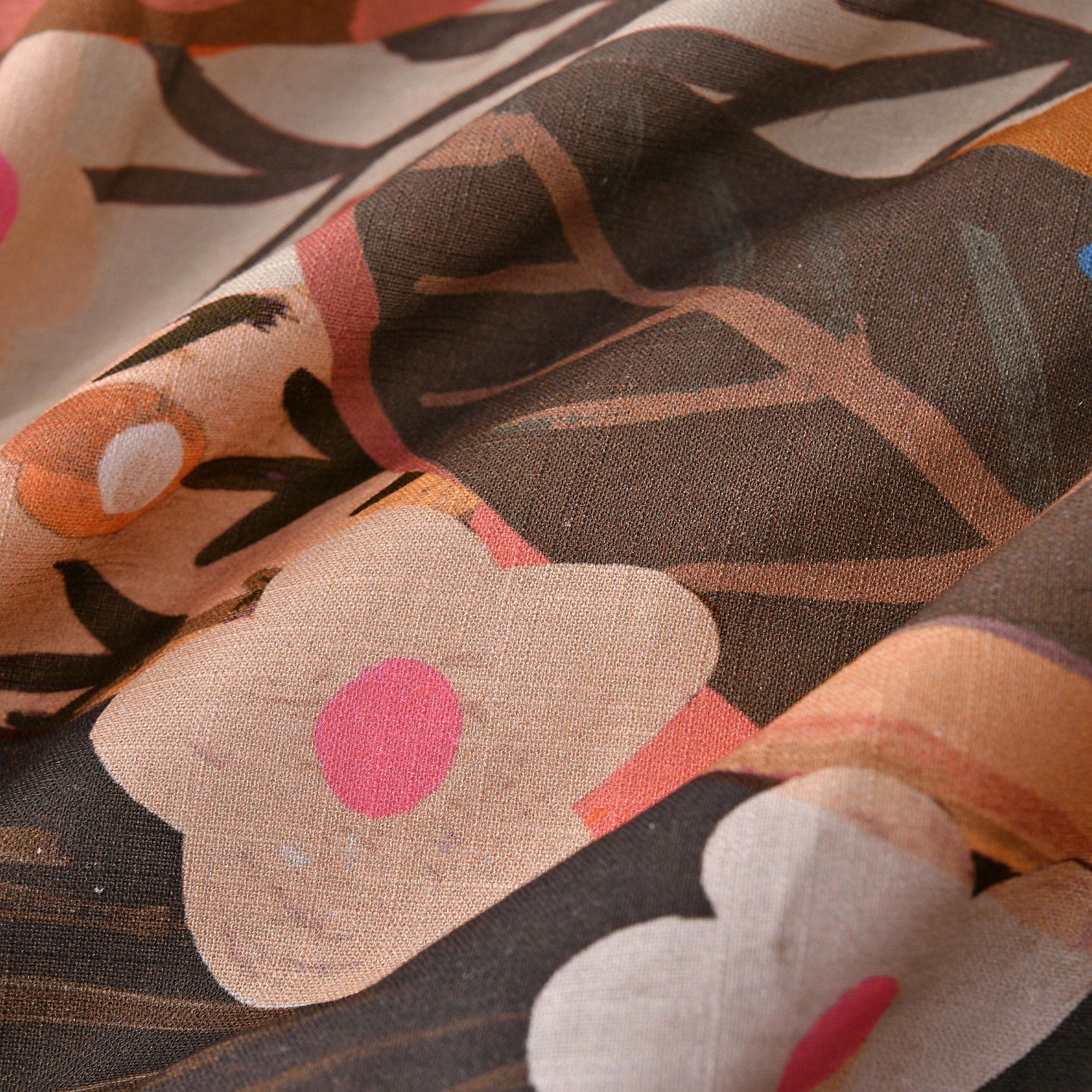 Close-up of fabric with abstract floral pattern in brown, pink, and orange.