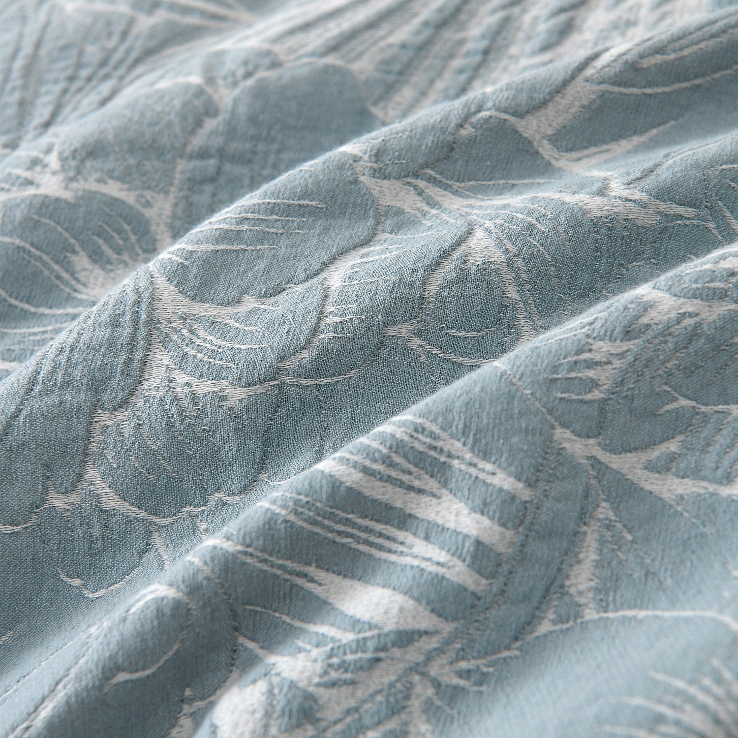 Textured fabric with leaf pattern in shades of blue and gray