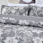 Floral bedding set with gray and white pattern on a bed.