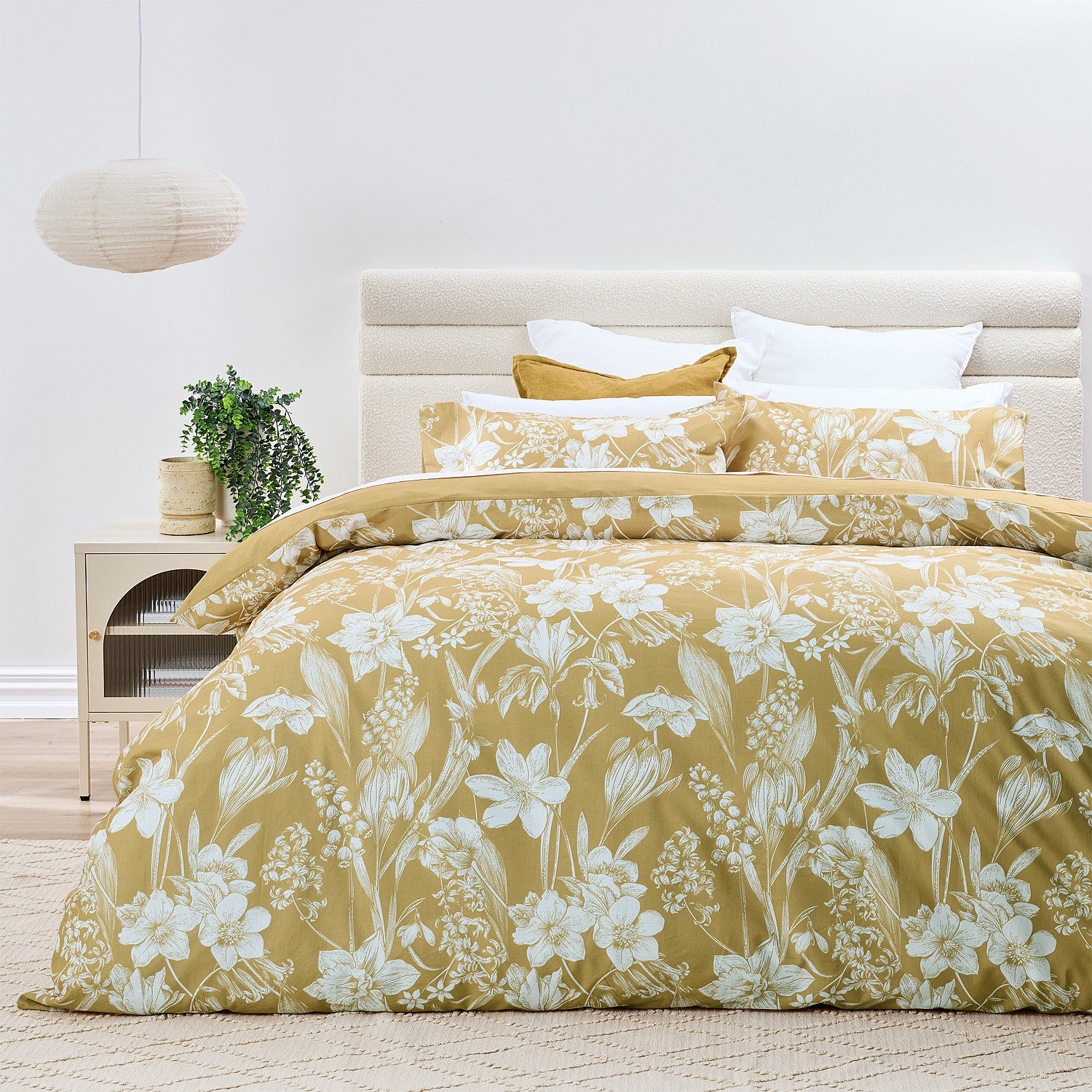 Bed with yellow floral bedding in a bright bedroom setting