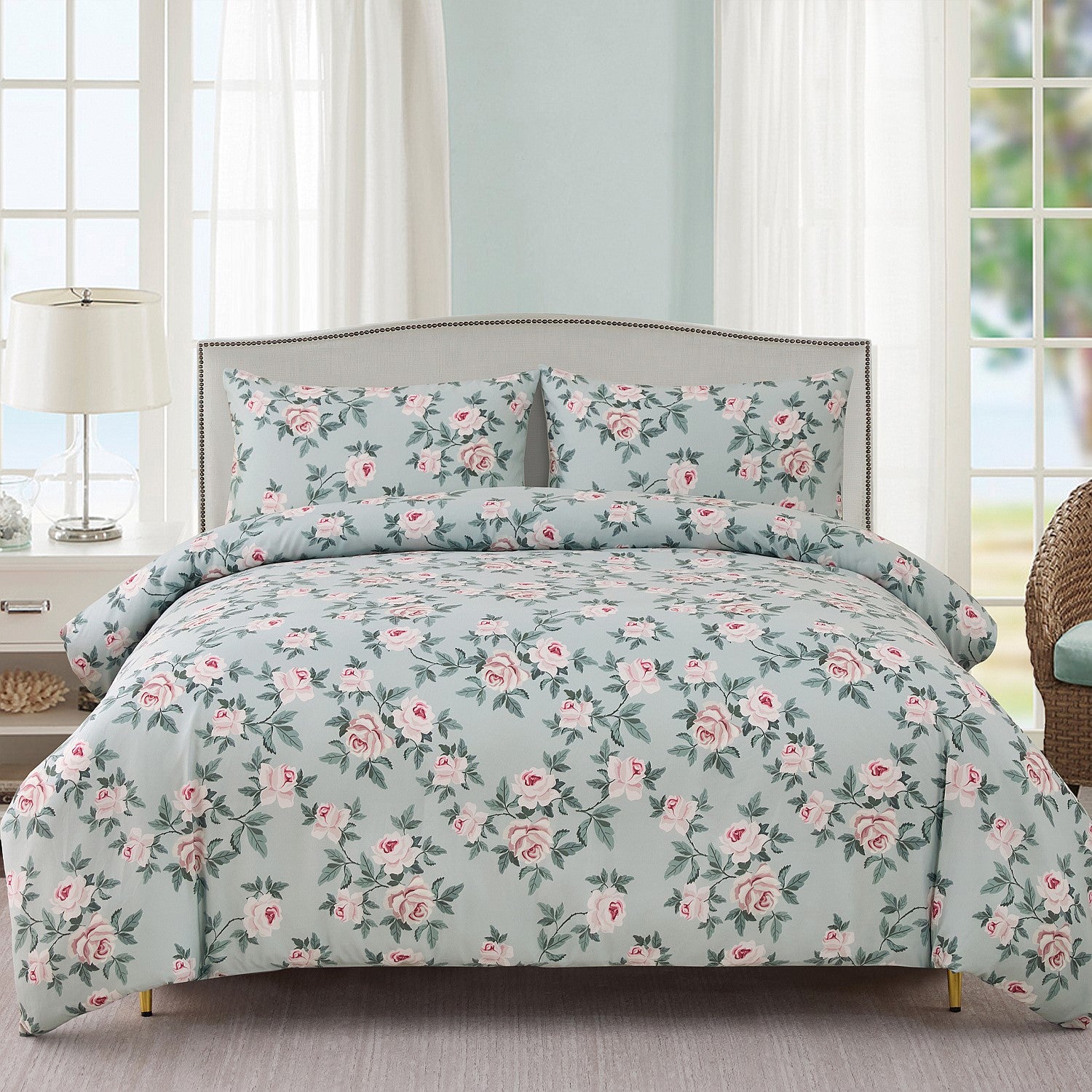 Floral bedding set on a bed in a bright room with light blue walls.