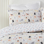 Dog-patterned bedding set on a bed with white pillows.