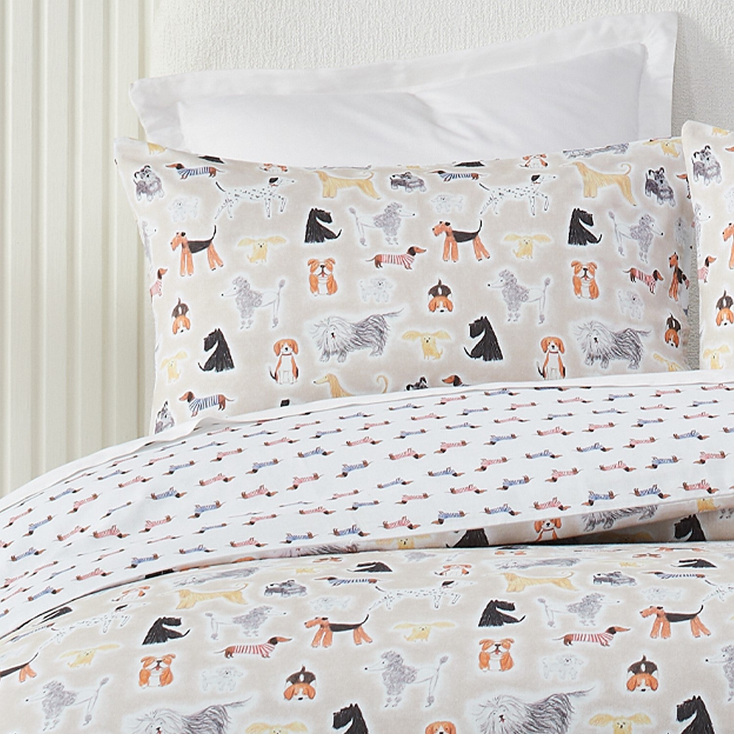 Dog-patterned bedding set on a bed with white pillows.