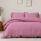 Pink checkered duvet set on a bed in a room with framed pictures on the wall.