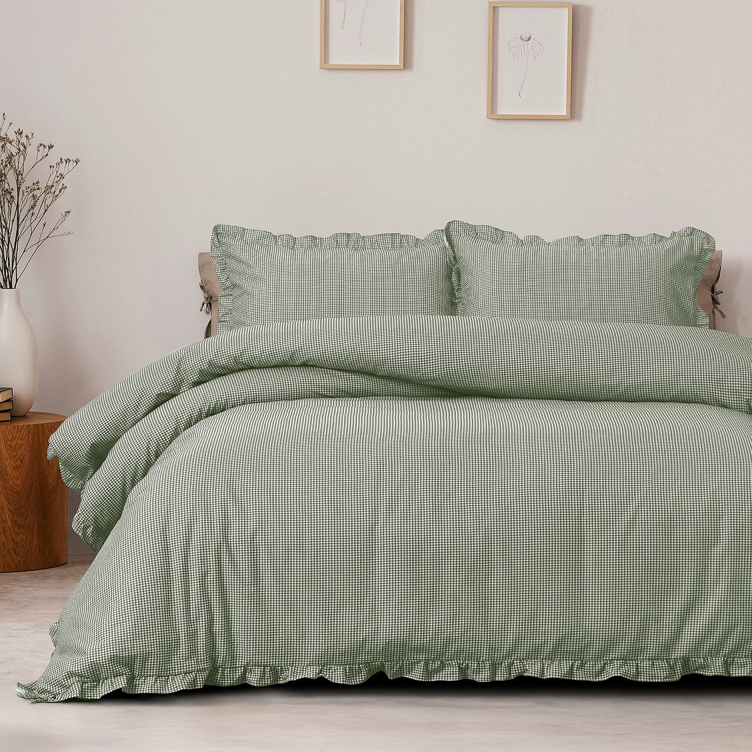 Green checkered bedding set on a bed in a bedroom with framed pictures on the wall.