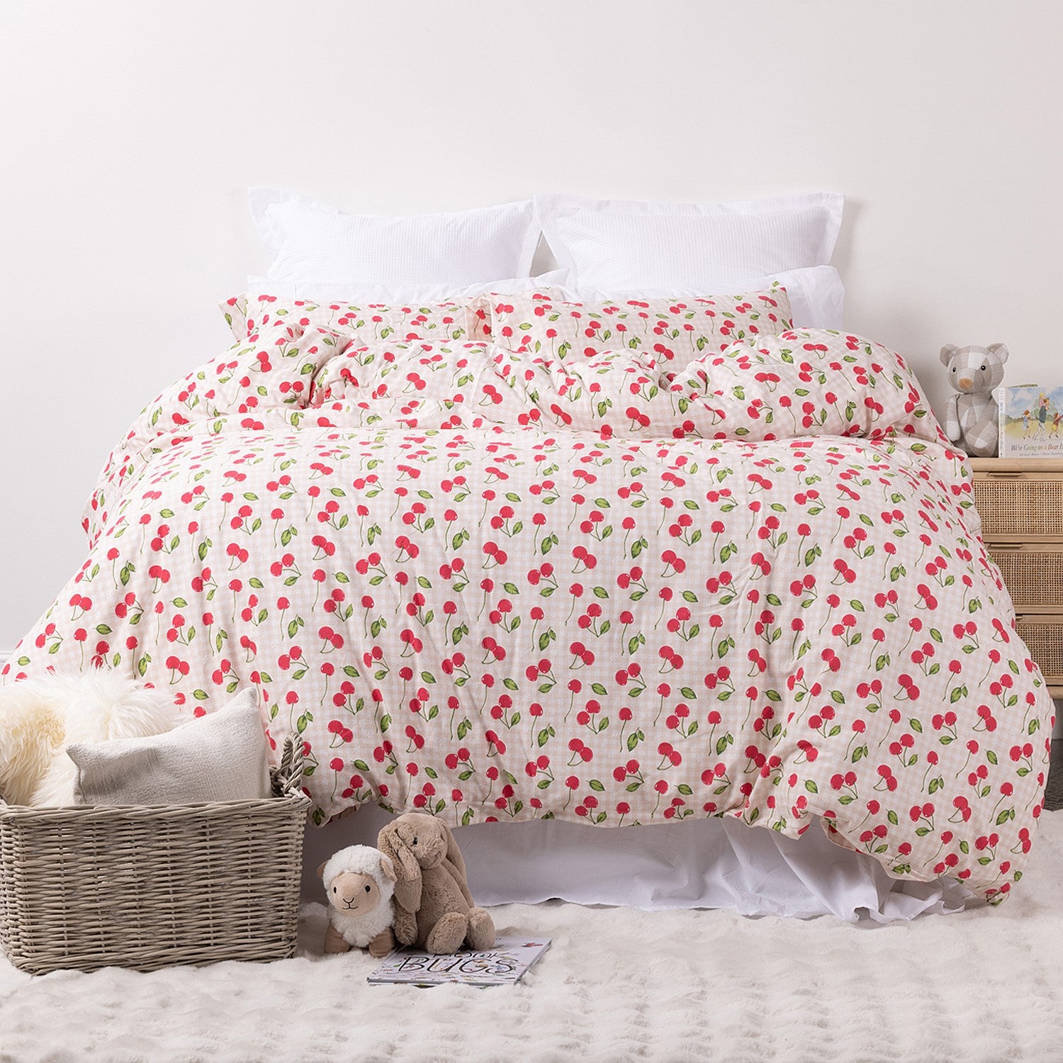 Kids red cherries print duvet cover set styled on a white bed in a neutral bedroom.