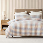 Bedroom with a bed featuring plaid bedding, a wooden nightstand, and striped wallpaper.