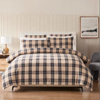 Plaid bedding set on a bed in a bedroom with striped wallpaper and a lamp.