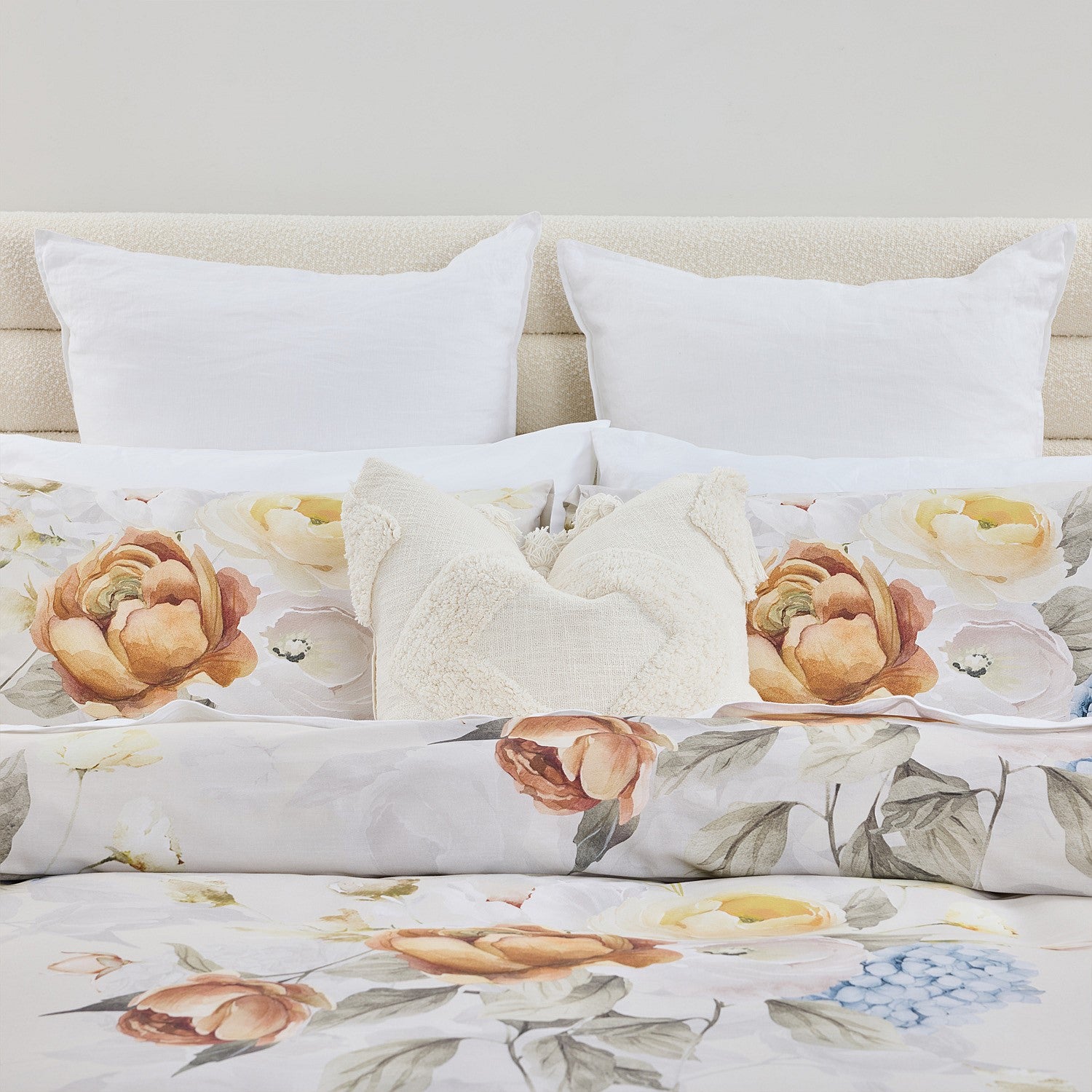 Floral bedding set with white pillows on a neutral background