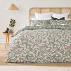 Floral patterned bedding set on a bed with a wooden headboard in a room setting.