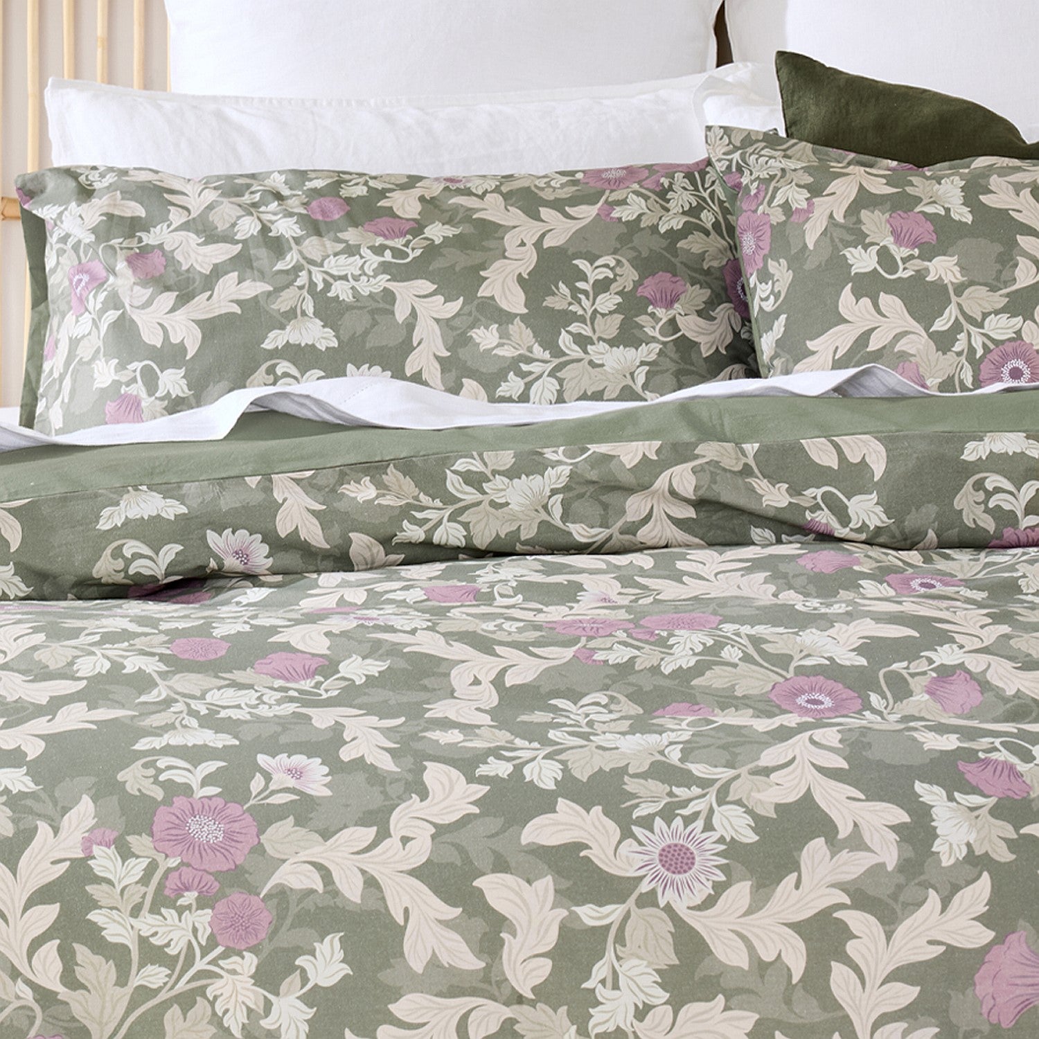 Floral patterned bedding set on a bed with white pillows.