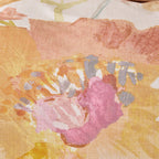 Close-up of a floral pattern with pink and yellow colors on a textured fabric background.