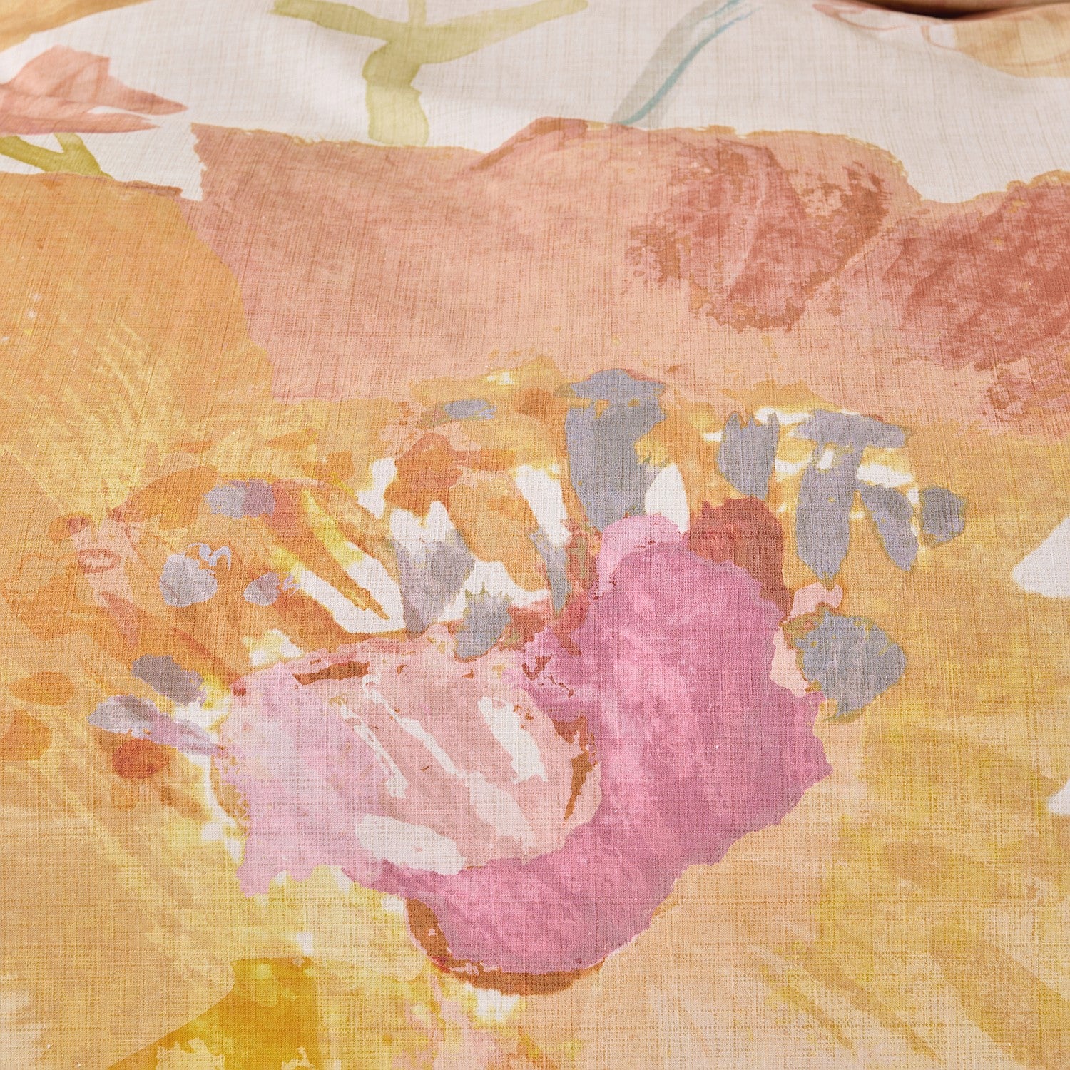 Close-up of a floral pattern with pink and yellow colors on a textured fabric background.