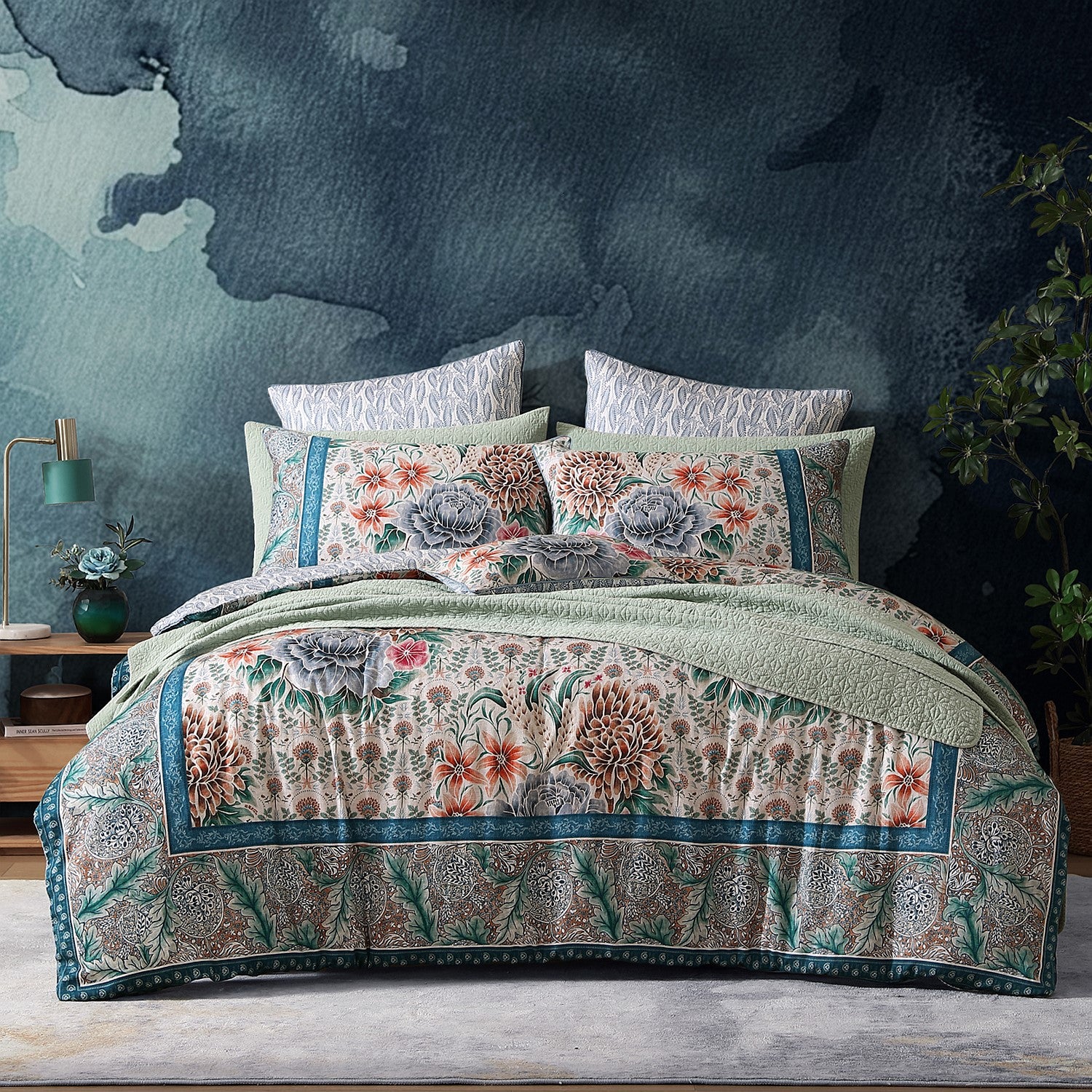 Floral patterned quilt and pillows on a bed with a dark textured wall in the background.